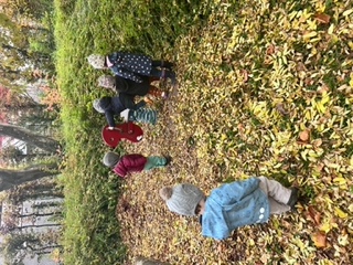 Kinder spielen zwischen Herbstlaub