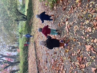 Kinder laufen durch einen Park mit Herbstlaub